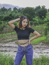 Portrait of beautiful young woman standing on land