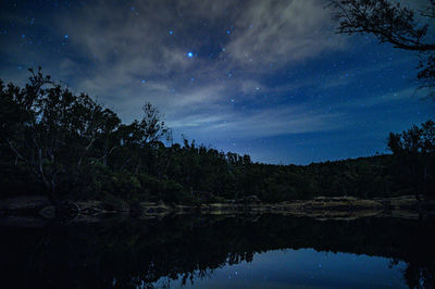 Scenic view of lake against sky at night