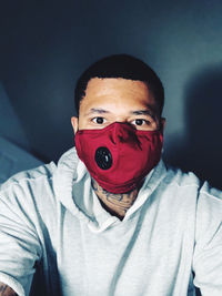 Portrait of man wearing flu mask against wall