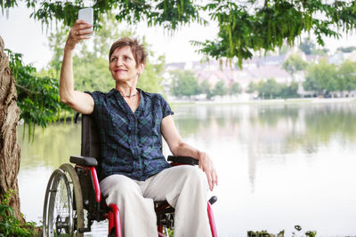 Full length of woman sitting on lake