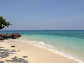 Scenic view of beach against clear blue sky