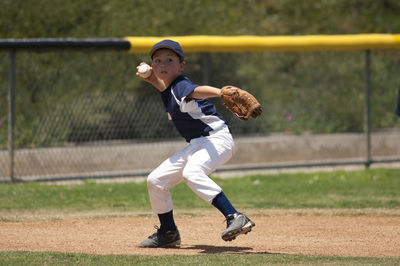 Little league baseball infielder ready to throw to first base