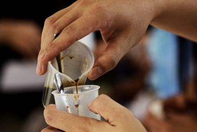 Close-up of barista pouring coffee in cup