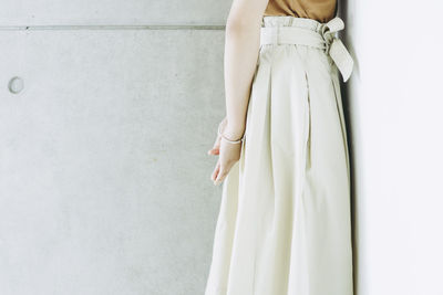 Midsection of woman standing by wall