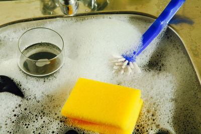 Utensils covered with soap sud in kitchen sink