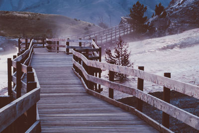 Footbridge over snow covered mountains