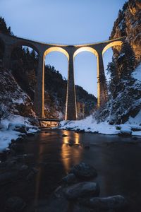 Bridge over river against sky during winter