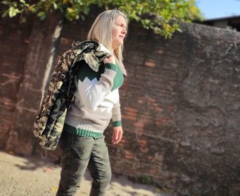 Full length of a smiling young woman standing outdoors