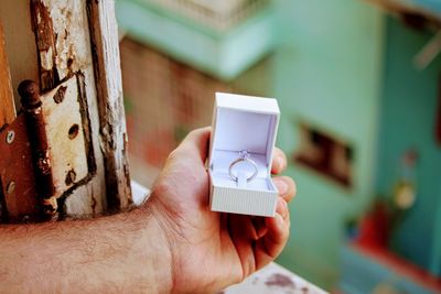 Cropped image of man holding ring