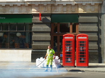Rear view of boy holding umbrella in front of street