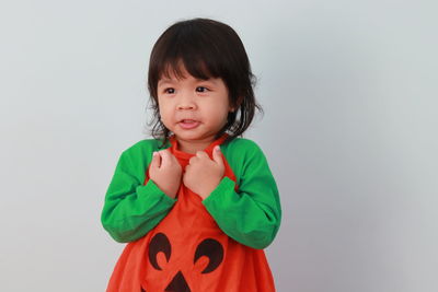 Portrait of cute girl standing against white background