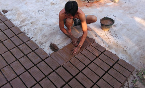 High angle view of man preparing bricks on ground