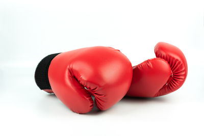 Close-up of red boxing gloves over white background