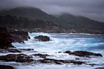 Scenic view of sea and mountains against sky