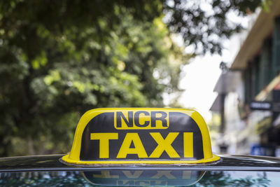 Taxi cab sign of taxi in delhi with city background, india. it's service in area around delhi.