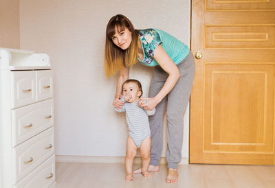 Full length of mother and son on floor