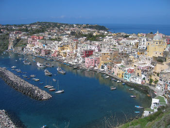 High angle view of cityscape by sea against clear sky