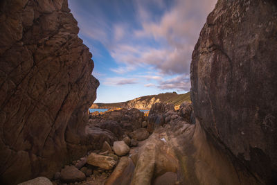 Rock formations on beach against sky