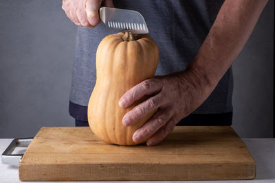 Cropped hand of man holding pumpkin