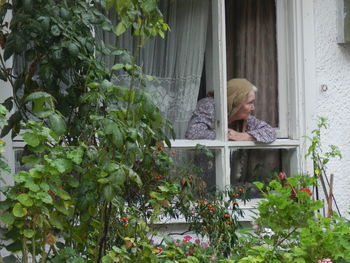 Woman looking through window