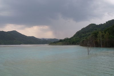 Scenic view of sea and mountains against sky