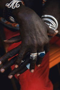 High angle of crop anonymous cool ethnic male in rings with precious stones and bracelets