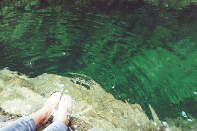 Low section of woman sitting on water