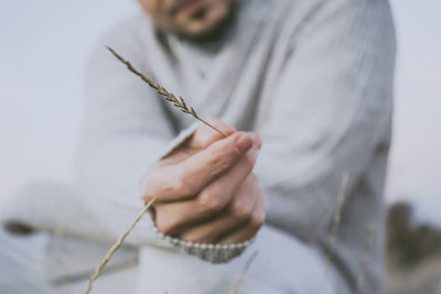 Midsection of man holding straw