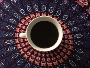 High angle view of coffee cup on tablecloth