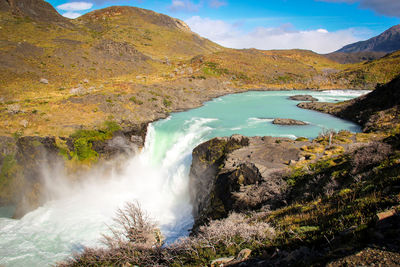 Scenic view of waterfall against sky