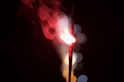 Close-up of illuminated lighting equipment against black background