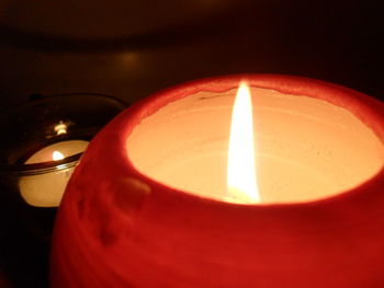 Close-up of lit candle in dark room