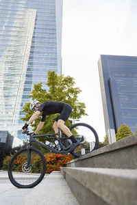 Young cyclist doing stunt with bicycle on steps