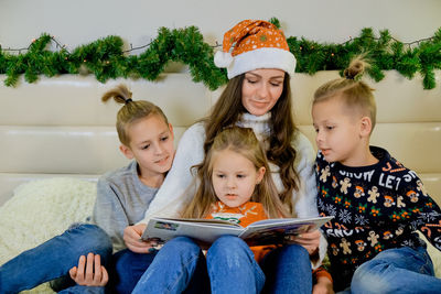 Mother reading book to children