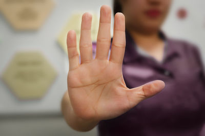 Midsection of woman gesturing stop sign