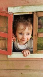 Portrait of smiling boy peeking outdoors