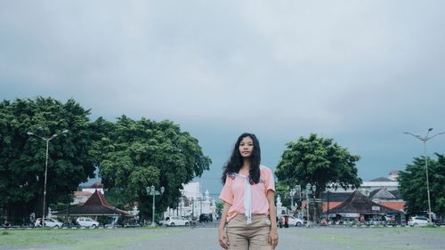 Portrait of woman standing against sky