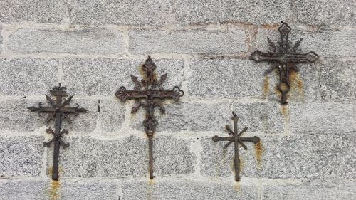 Cross sculpture against wall