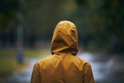 Rear view of man wearing raincoat standing outdoors