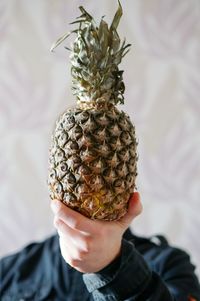 Close-up of man holding pineapple