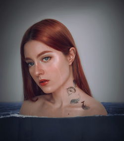 Portrait of young woman against wall