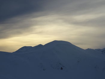 Scenic view of snowcapped mountains against sky during sunset