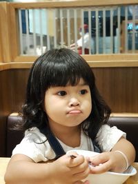 Portrait of cute girl sitting at home