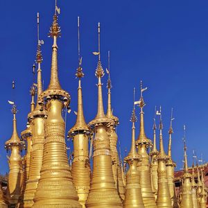 Low angle view of temple against building against clear blue sky