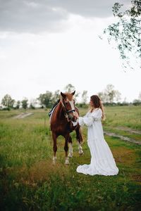 Young woman with horse on field