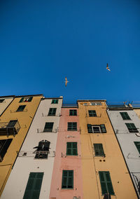 Low angle view of buildings against clear blue sky