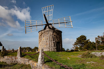 Traditional windmill on field against sky