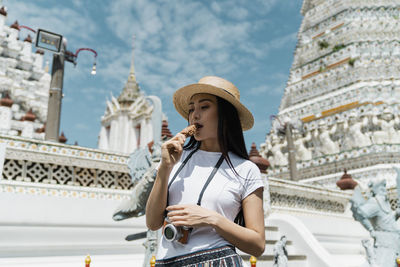Woman eating ice cream against temple
