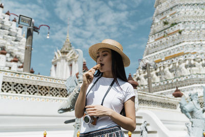 Midsection of man using mobile phone at temple