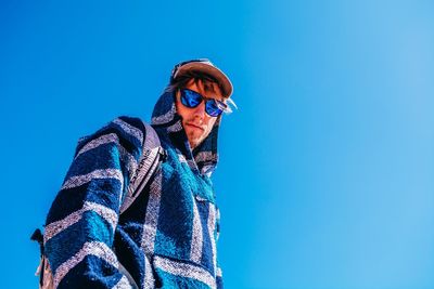 Low angle view of man against blue sky